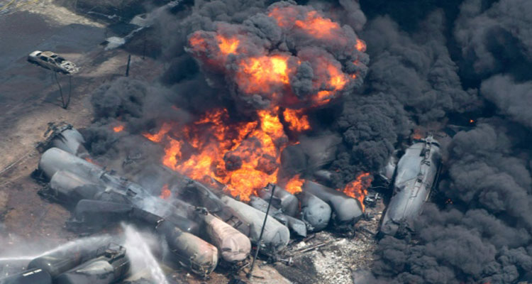 Smoke rises from railway cars that were carrying crude oil after derailing in downtown Lac-Megantic, Que., on July 6, 2013. (Paul Chiasson/THE CANADIAN PRESS)
