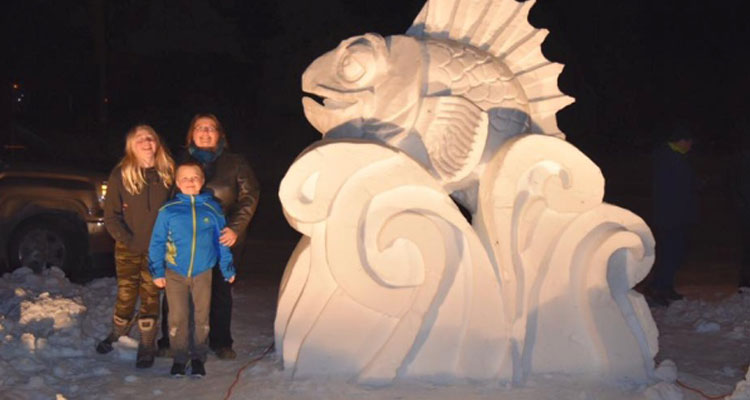 The Puckett family stands beside the snow sculpture, Jason's Fish, a tribute to the late Jason Puckett. (Shelly Puckett/Facebook)