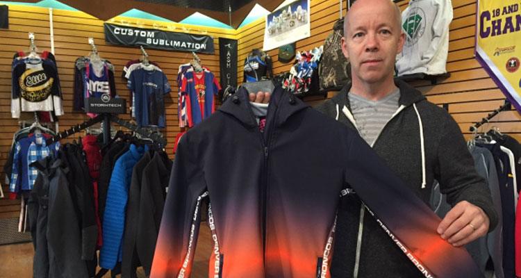 Peter Wills holds a completed jacket made for the Denver Broncos cheerleaders. (Victoria Dinh/CBC)