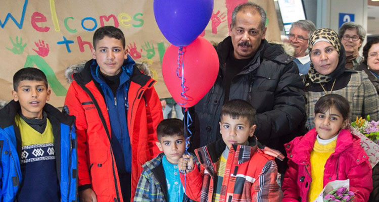 The Ayash family from Syria pose for a photograph after arriving in Halifax on Monday. The family is being sponsored by a community group in Lunenburg, N.S., and will soon move into a home in the historic town. (Andrew Vaughan/Canadian Press)
